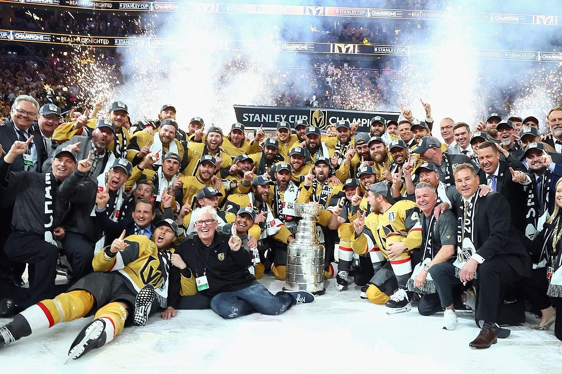 Las Vegas Knights owner Bill Foley, wearing glasses and keeling on the ice to the left of the Stanley Cup trophy, celebrates with the team after winning the NHL title. Foley also is the chairman of Jacksonville-based Fidelity National Financial Inc.