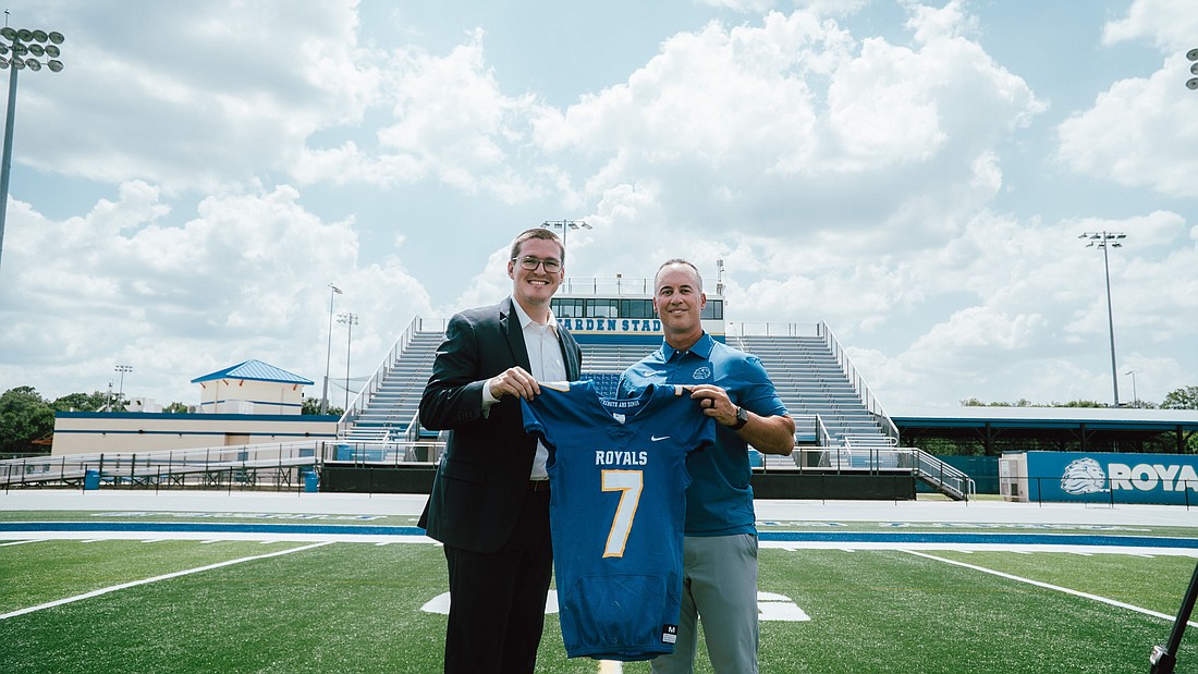 Jeff Conaway and TFA Athletic Director Will Cohen hold a jersey with Conaway’s favorite number, No. 7.