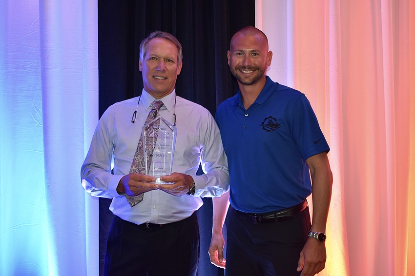 Florida Elevator president Jay Perry was presented the Medium Business of the Year award by Evan Phillips of Boat Guys of Sarasota