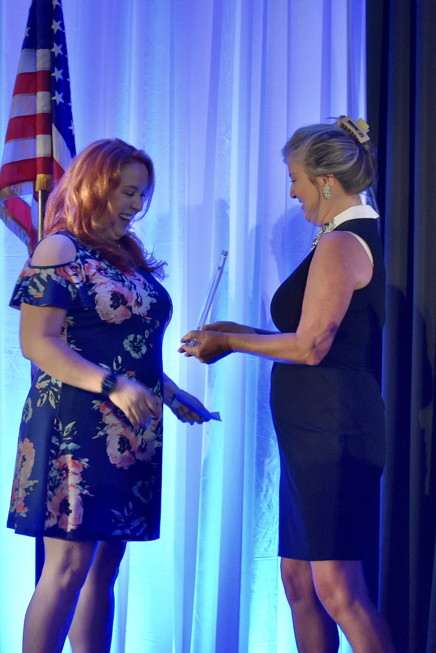 Stage Door Studios owner Jill Athridge accepts an award from Greater Sarasota Chamber of Commerce president and CEO Heather Kasten