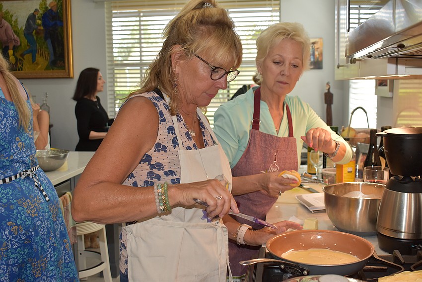 Sarasota's Roxanne Sima and East County's June Braithwaite take their turn at the stove during the cooking class.