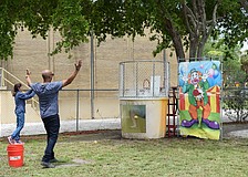 Barry Gaines aims perfectly to dunk people in the dunk tank while other employees cheer around him.