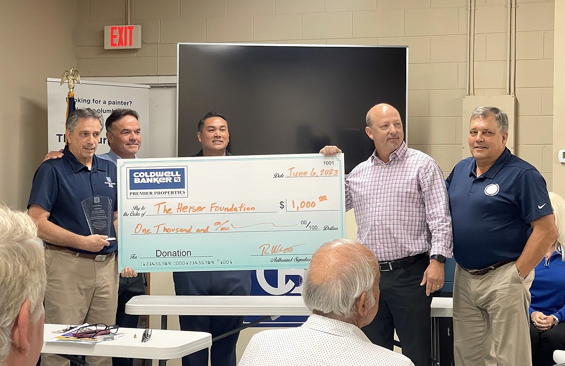 Coldwell Banker Premier Properties presents Tom Heiser, left, a check for $1,000 to the Heiser Foundation to celebrate Heiser's 30 years with the company. Courtesy photo