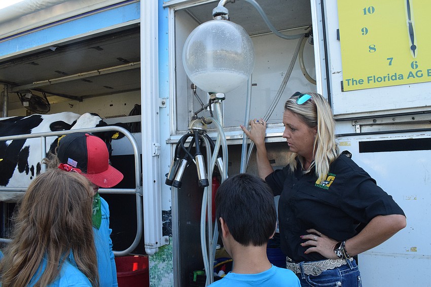 Junior Ranchers campers listen as Courtney Dakin with the Florida Agriculture Experience explains how a cow is milked.