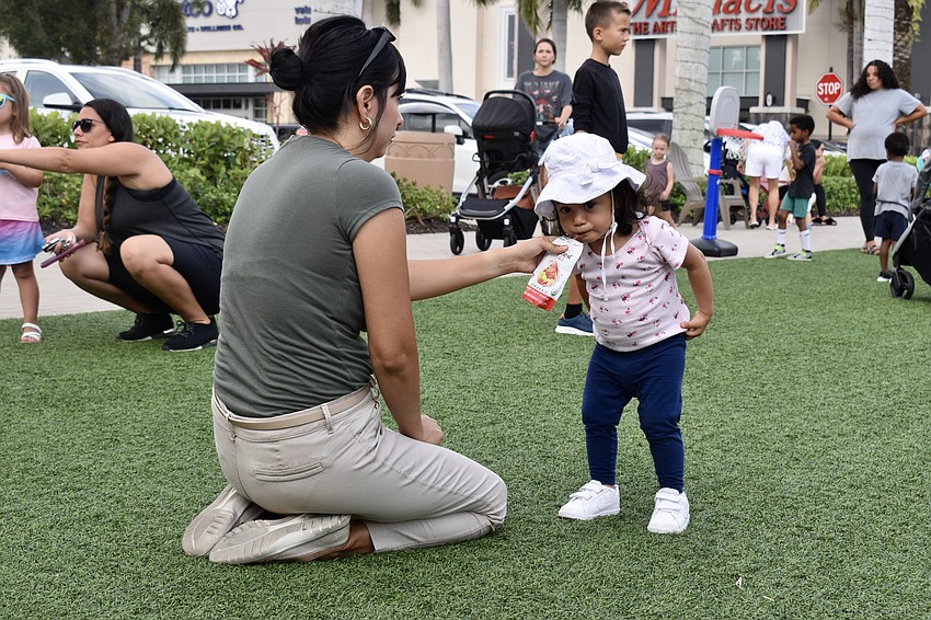 Lakewood Ranch resident Sofia Hernandez stops for a juice break, while mom Alicia assists. Each kid gets one free juice at the UTC Kids Club.
