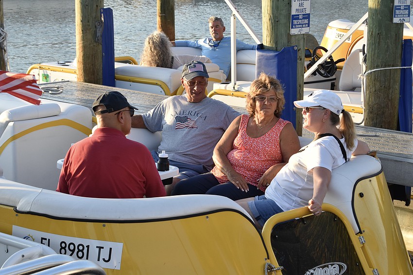 Peter Delneky, Joe and Evelyn Vignola, and Mary Delneky chat in a docked boat at the park.