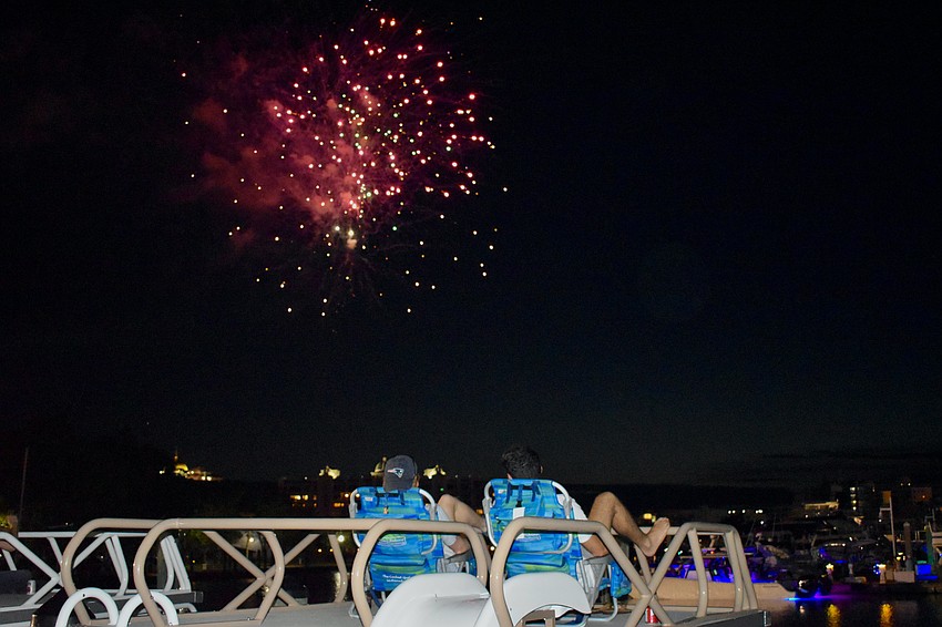 Nate Kennelly and Alex St. Lifer enjoy a boat rooftop view of the fireworks.