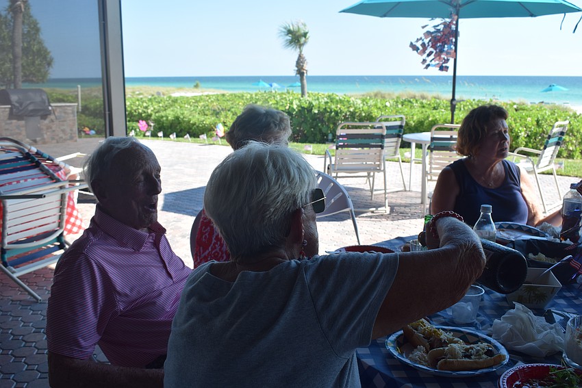 Residents of Seaplace Condo have Fourth of July dinner on the clubhouse patio.