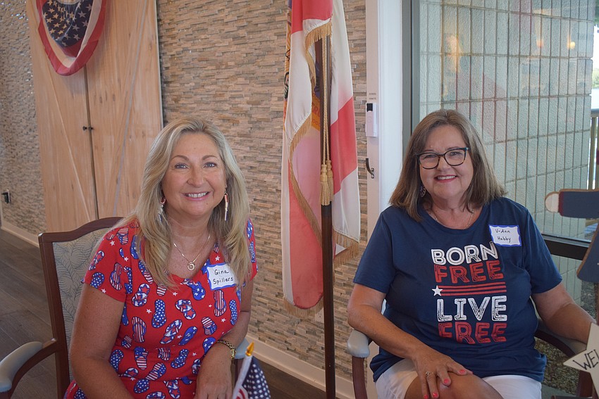 Gina Spillers and V-Ann Hobby handed out name tags as people came into the Longboat Harbour Fourth of July party.