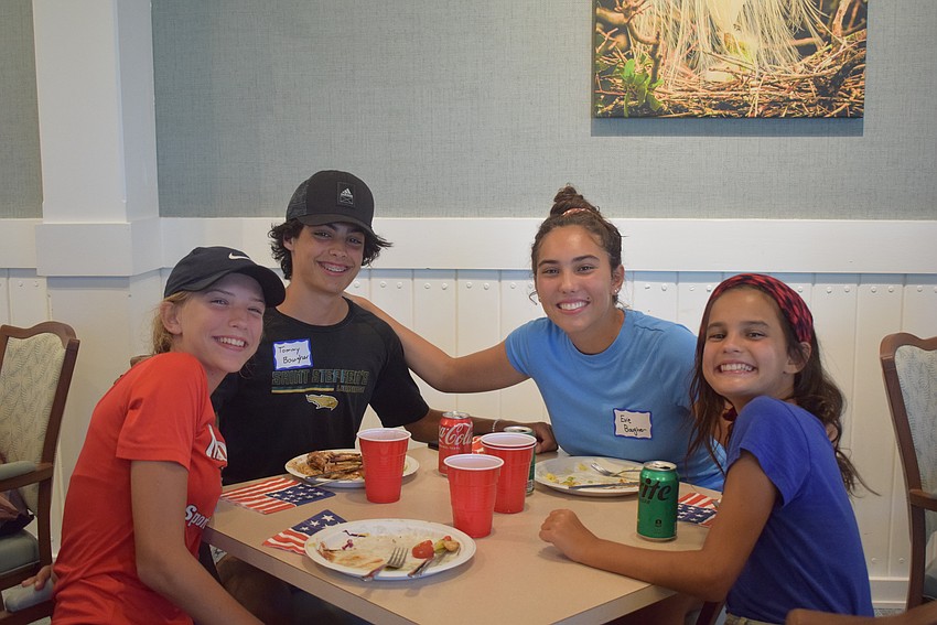 The Baugher children enjoy the food provided at the Longboat Harbour Fourth of July party.
