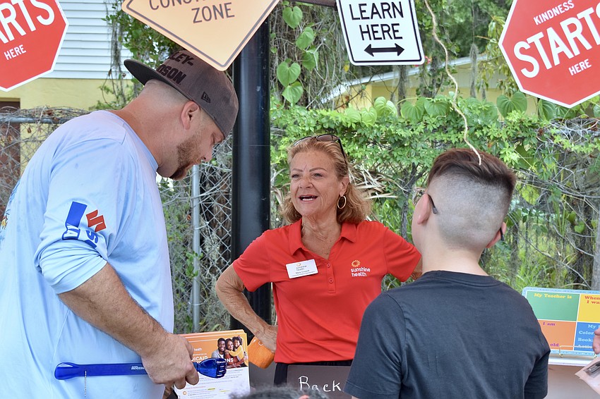 Jeremy Schlosser, Mary Crouch of Sunshine Health, and 11-year-old Joey Schlosser speak with one another.