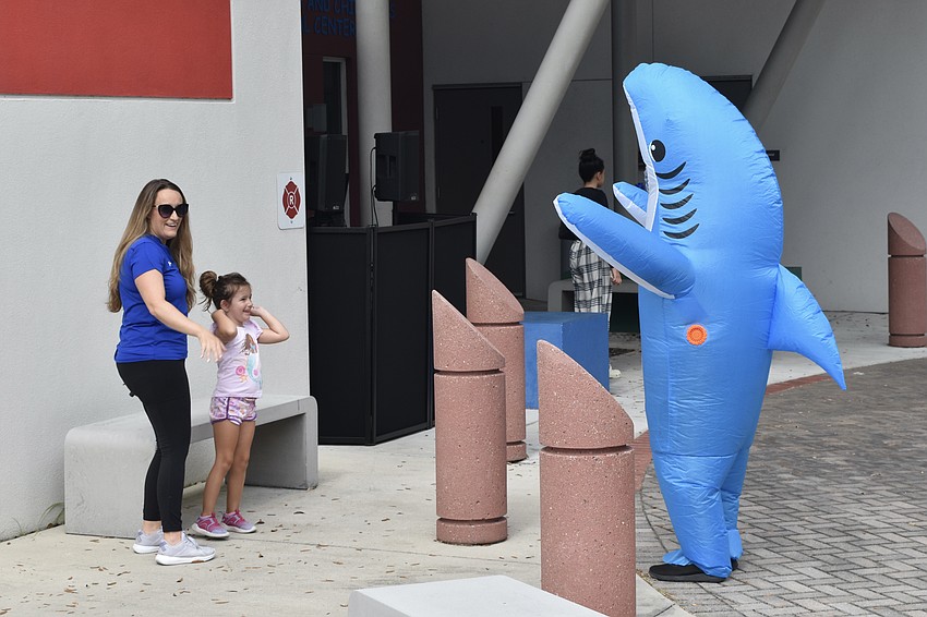 CenterPlace Health employee Shannon Carrasco and 4-year-old Everleigh Carrasco greet Abi Valez, who is dressed as a shark.