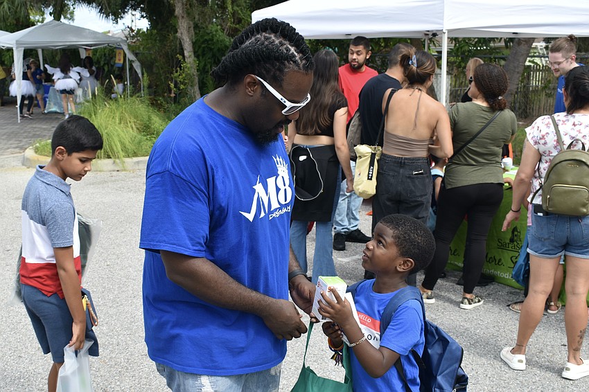 Ira Jenkins and 5-year-old Kingston Jenkins  discuss the items they are gathering.