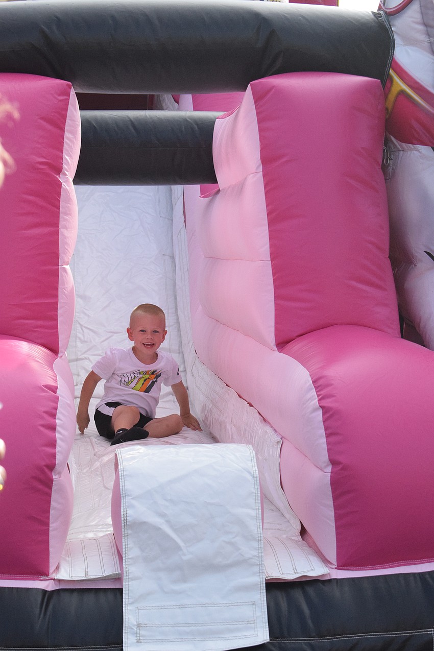Bradenton's Cooper Adams, who is 3, smiles as he slides down. The kids zone has three different inflatables for children to enjoy.