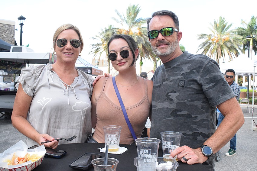 Waterside's Cindy Robertson, Lindsey Robertson and Stewart Robertson eat and dink while waiting for friends to join them at Music on Main.