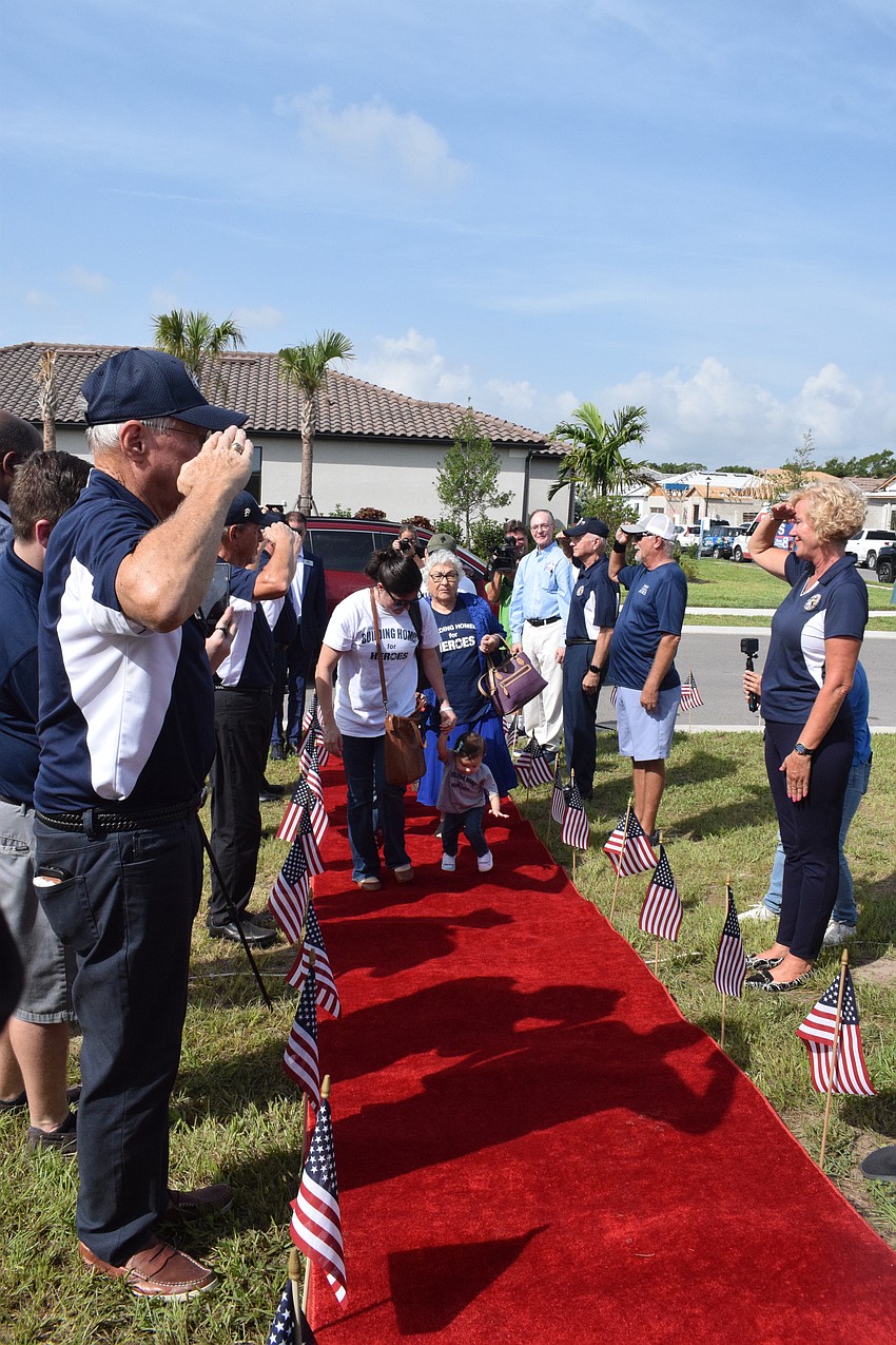 The Gaytan family is saluted by Del Webb veterans as they walk the red carpet.