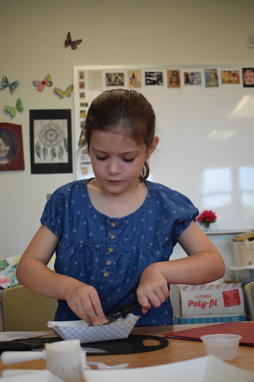 Brynn Finley, a rising second grader, grates garlic for the potsticker filling.