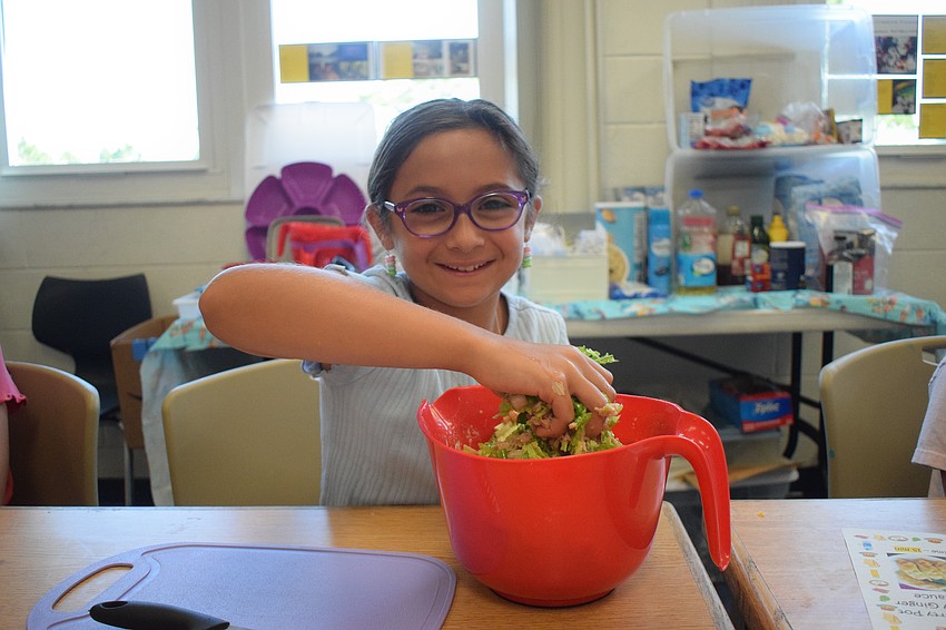 Brooke Oliver, a rising fifth grader, mixes all the ingredients for the potsticker filling. 