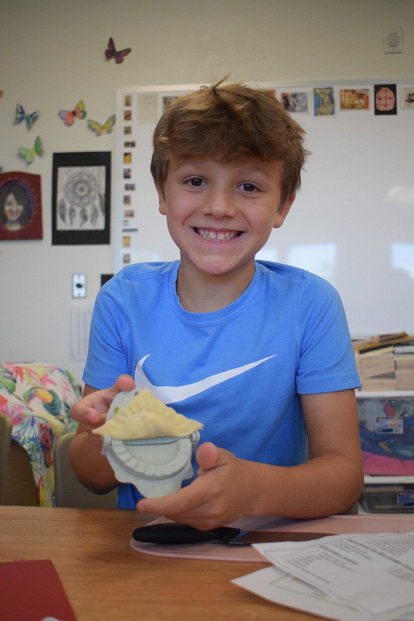 Drew Randenburg, a rising third grader, can't wait to have his perfectly pressed potsticker fried so he can try them for the first time.