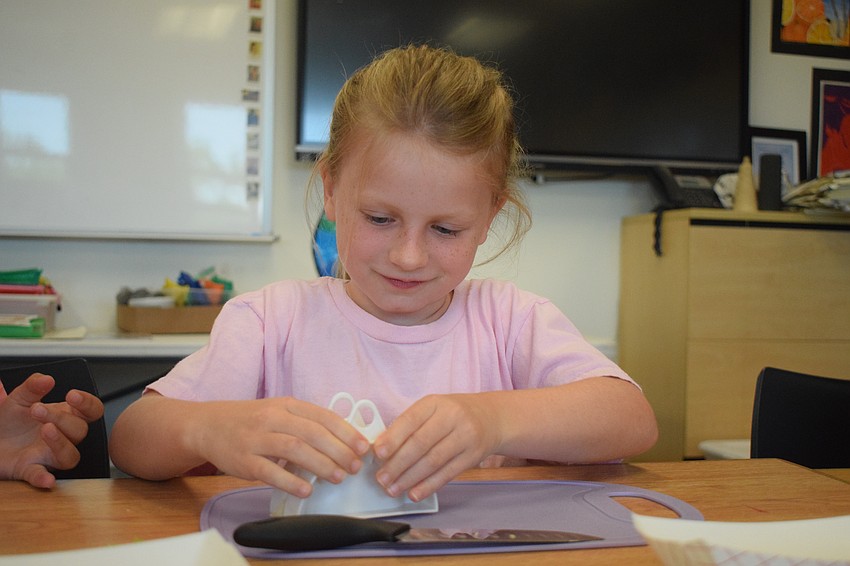 Rising second grader Summer Allen presses together her wonton wrapper to encase the filling.