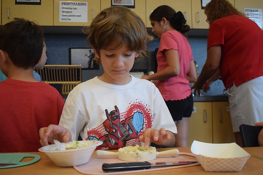 Joshua Rodriguez, a rising second grader, makes sure he follows every step on how to make potstickers.