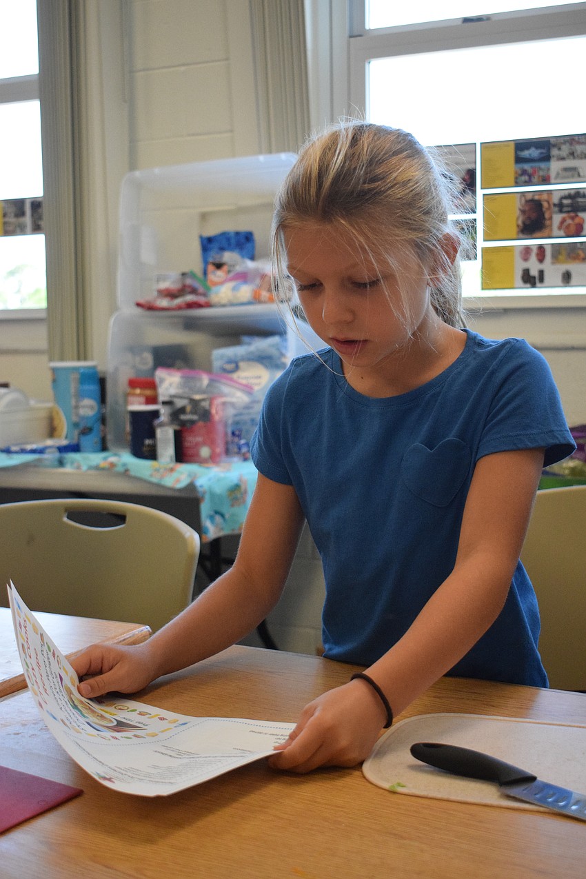 Hailey Royce, a rising third grader, reviews the recipe for potstickers.