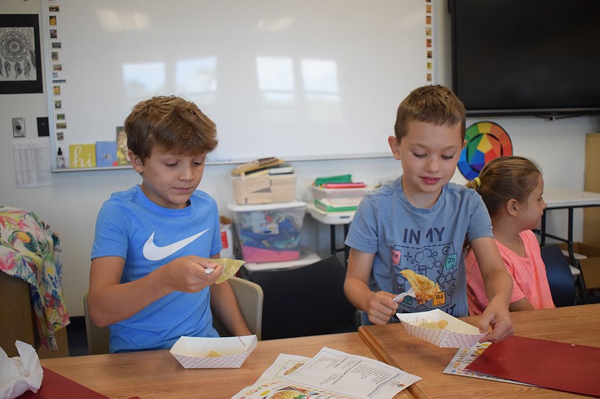 Drew Randenburg, a rising third grader, and Liam King, a rising second grader, try potstickers for the first time. They made them from scratch.