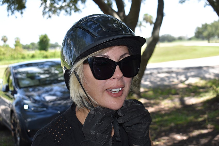 Safety first. Karen Medford secures her helmet before the lesson.