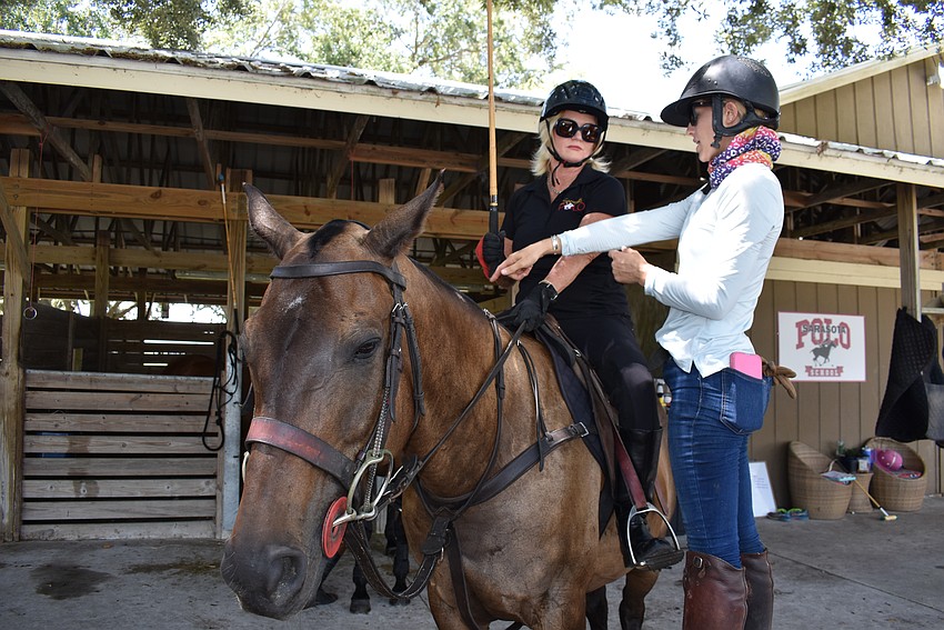 Jackie Tamminga listens to tips before her first lesson from Ashlie Osburg at the Sarasota Polo Club.