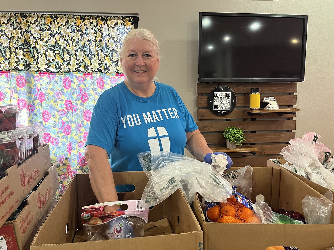 Jan Ricard, a volunteer at Woodland Community Church's food bank, goes through fruits as they prepare for food distribution.