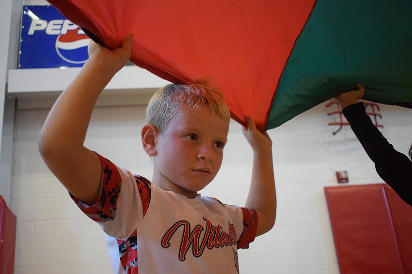 Hayden Harvey, who is 6, scopes out another red spot he can get to before the parachute lands on the ground.