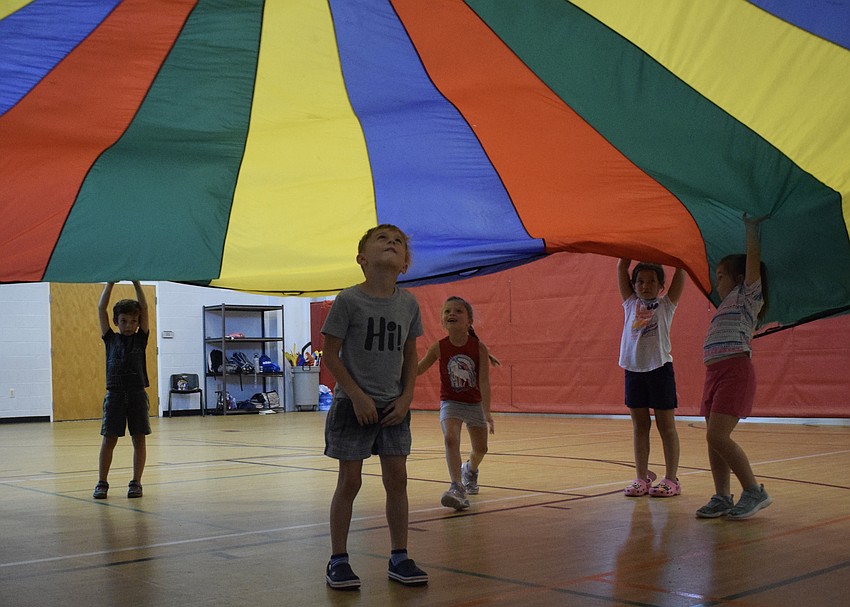 Devin Schneider, who is 5, watches as the parachute gets closer to landing on him.