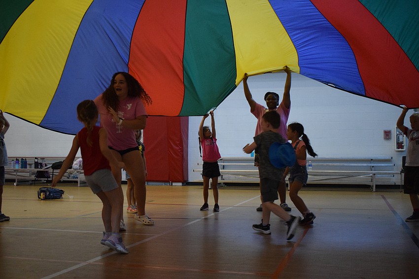 It's a mad race among counselors and campers to find a spot outside the parachute before it lands on them.