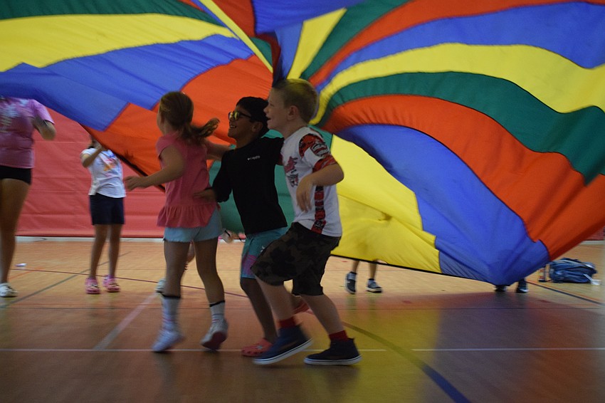 Ellie Kil, Matteo Gonzalez and Hayden Harvey, who are all 6 years old, race to escape the parachute before it lands on them.