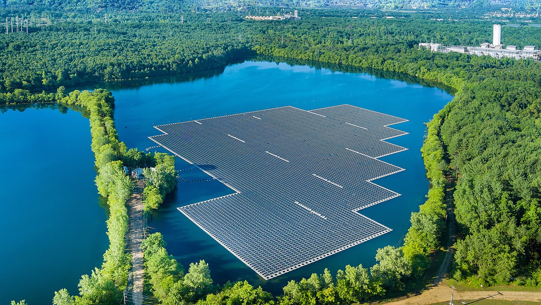 An aerial view of floating solar panels cell platform on a body of water.