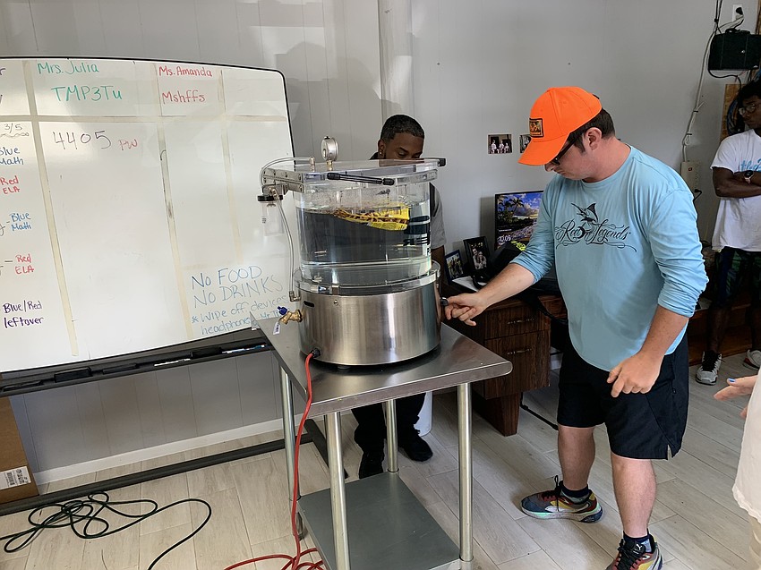 Dylan Mayes uses the Pouch Burst Test machine at PPi Technologies Group. The machine tests the seal of the pouches before distributing the products to consumers.