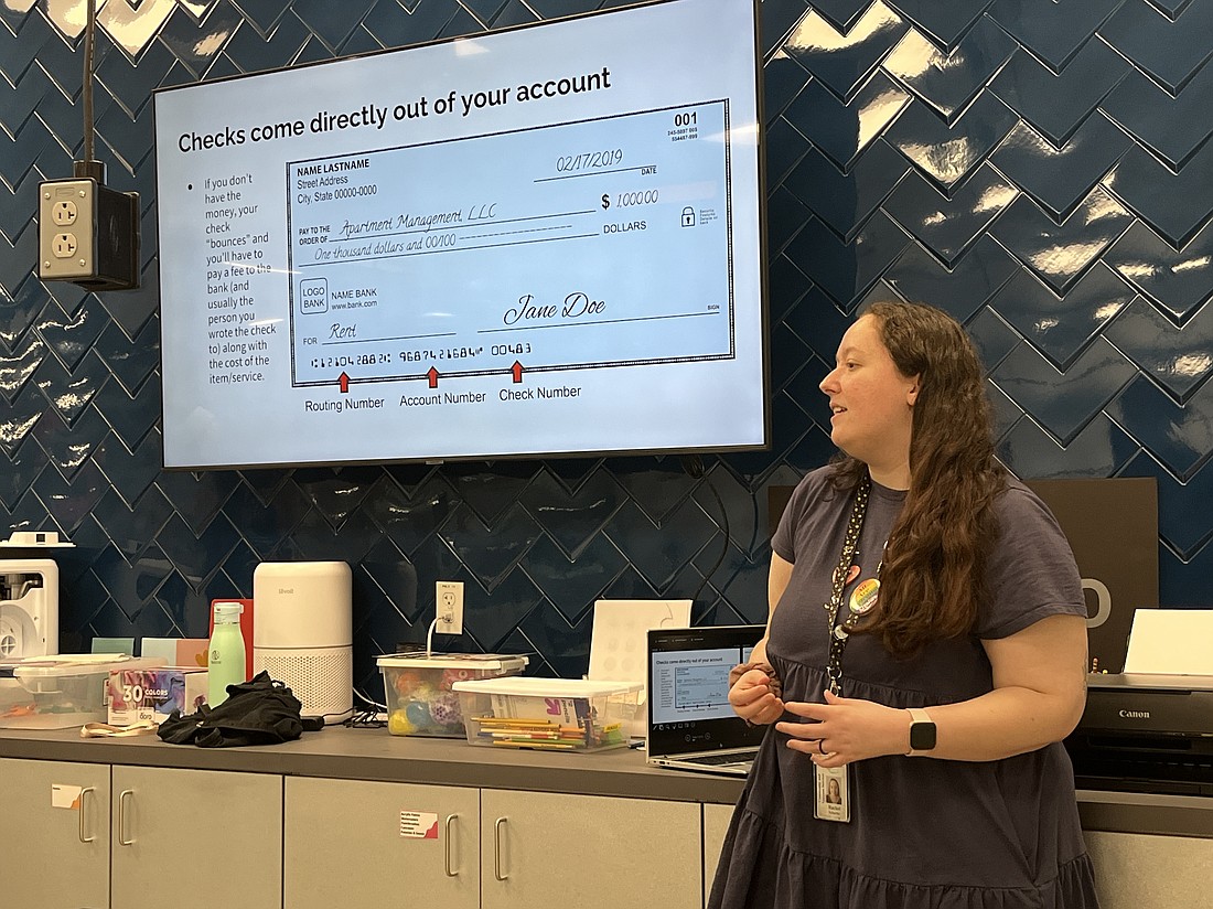 Rachel Scharbo, the teen librarian at Braden River Library, goes over opening a checking account and savings account during an Adulting 101 session.