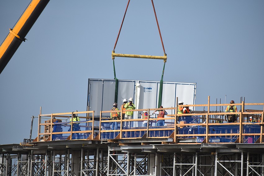 Media and guests watched from neighboring PopStroke as the acrylic window for the Gulf of Mexico Gallery tank is lowered from above the aquarium to a spot on the first and second floors.
