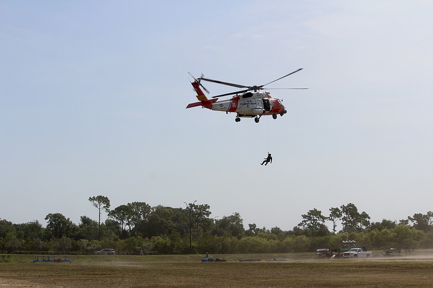 Campers get a demonstration on what goes into landing a helicopter without a pad. Someone has to check the ground for foreign objects first.