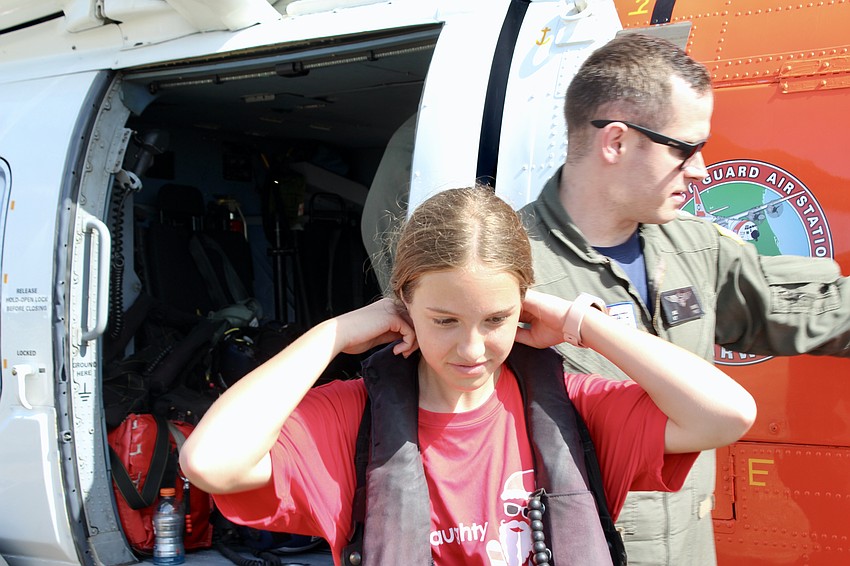 Parrish resident Palin Morris puts on a survival vest before stepping into the cockpit.