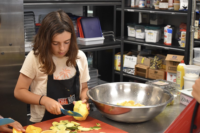 Cecilia Antista, 11 years old, slices fruit.