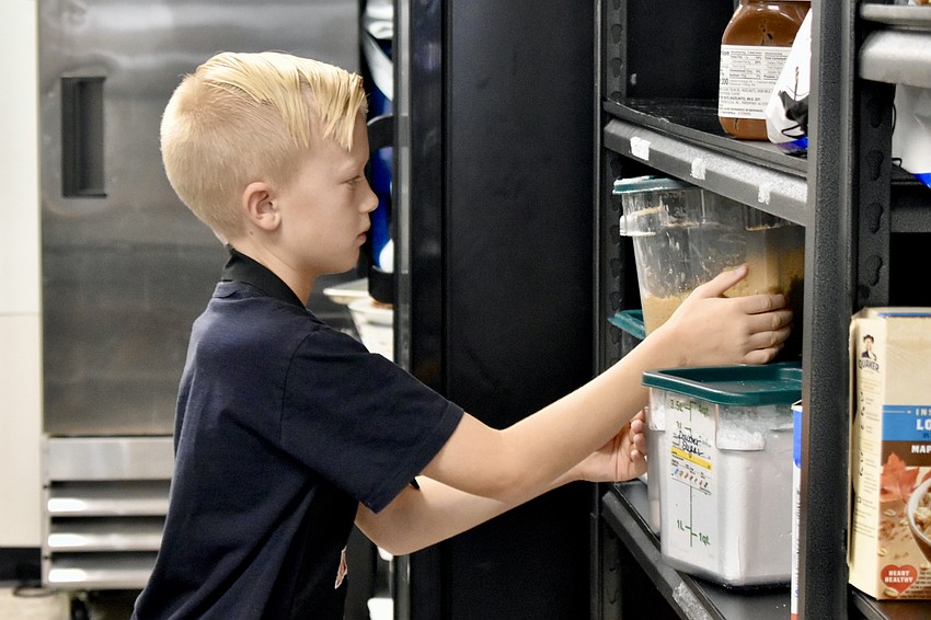 Jaxson Heid, 12, returns ingredients to the shelf.