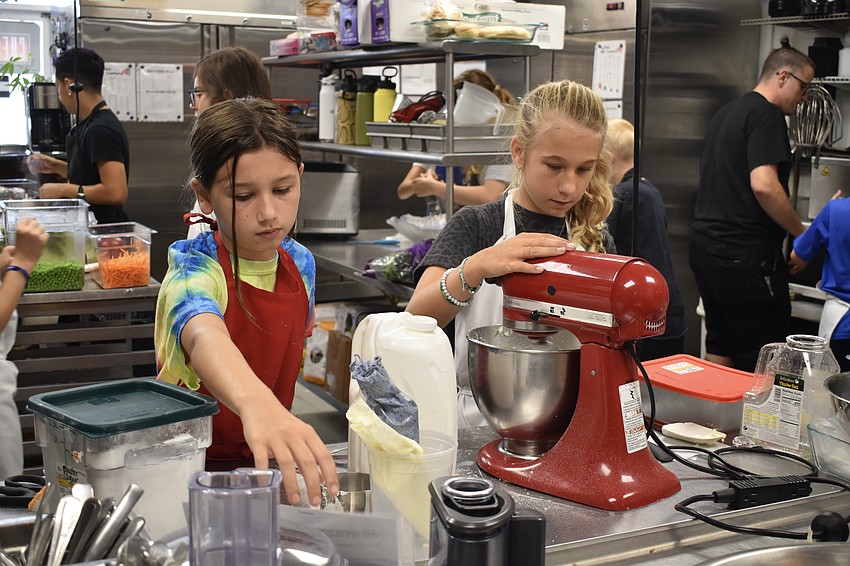 Sophia Reid, 11, and 11-year-old Alexis Rosebrock mix icing together.
