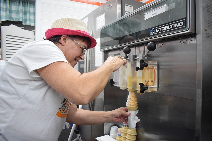 Marie Lovy prepares an ice cream cone for a customer on Mixon Fruit Farms' final day.