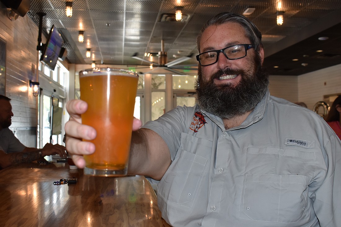 LJ Govoni, president of Fat Point Brewing Co., offers up a Keywaydin Island blonde ale at the grand opening July 28 at UTC.