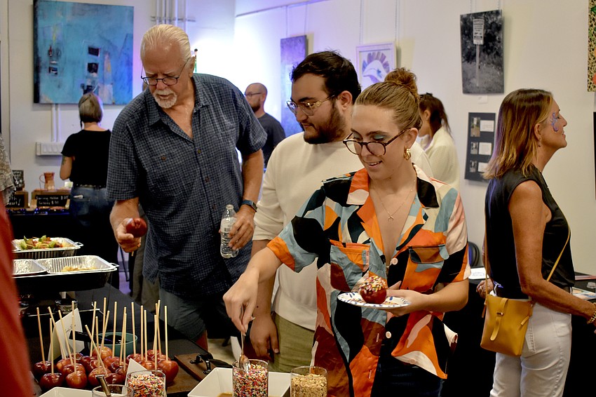 Steve Mann, Juwan Rivas, and Cas Bradley gather candy apples.