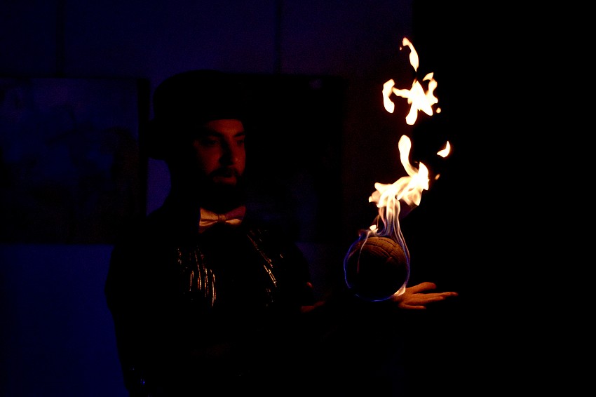 Illusionist Marshall Chandler handles an orb as it is set aflame.