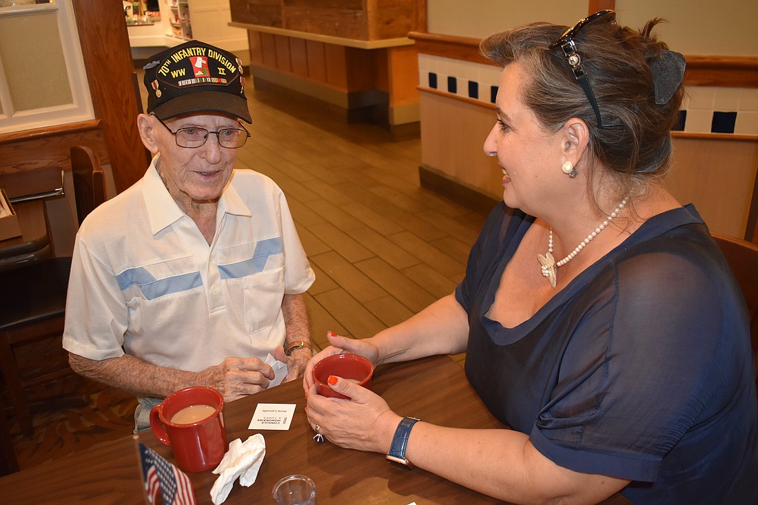 John Skeen, once a World War II U.S. Army infantry soldier, visits with Anne Lancelle, an Honorary Consul representing France, during a veterans meeting July 27 at Bob Evans restaurant in East County.
