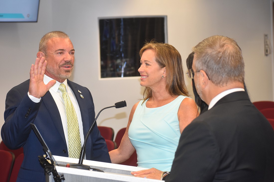 Raymond Turner, with his wife Debbie at his side, takes the oath of office to become the newest Manatee County Commissioner Aug. 1 at the Manatee County administration building.