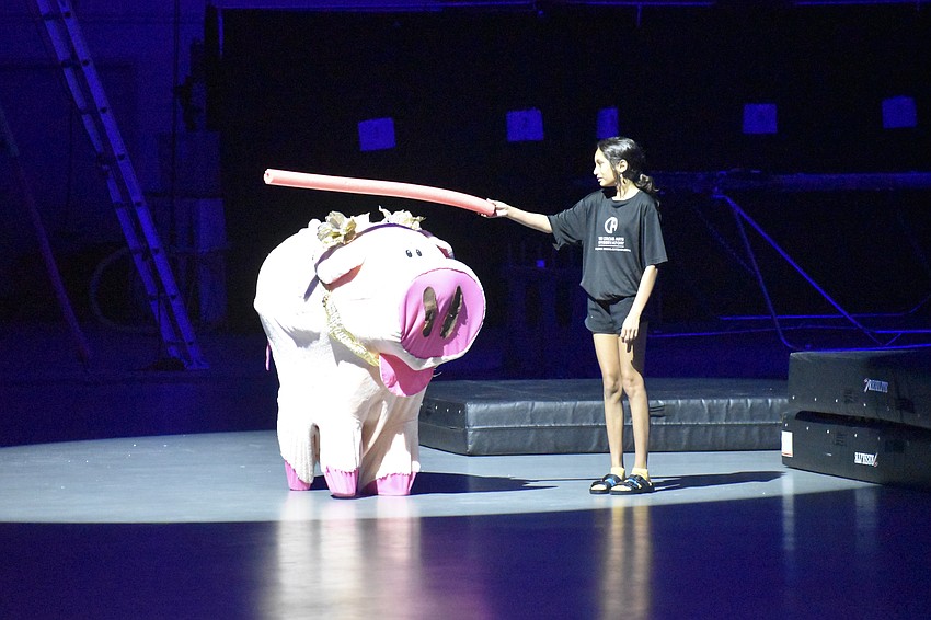 Geoffrey the Pig does the limbo for counselor in training Elin Harvey, 12.